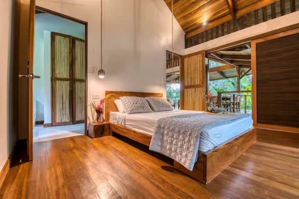 A bedroom at the venue, open to the surrounding nature