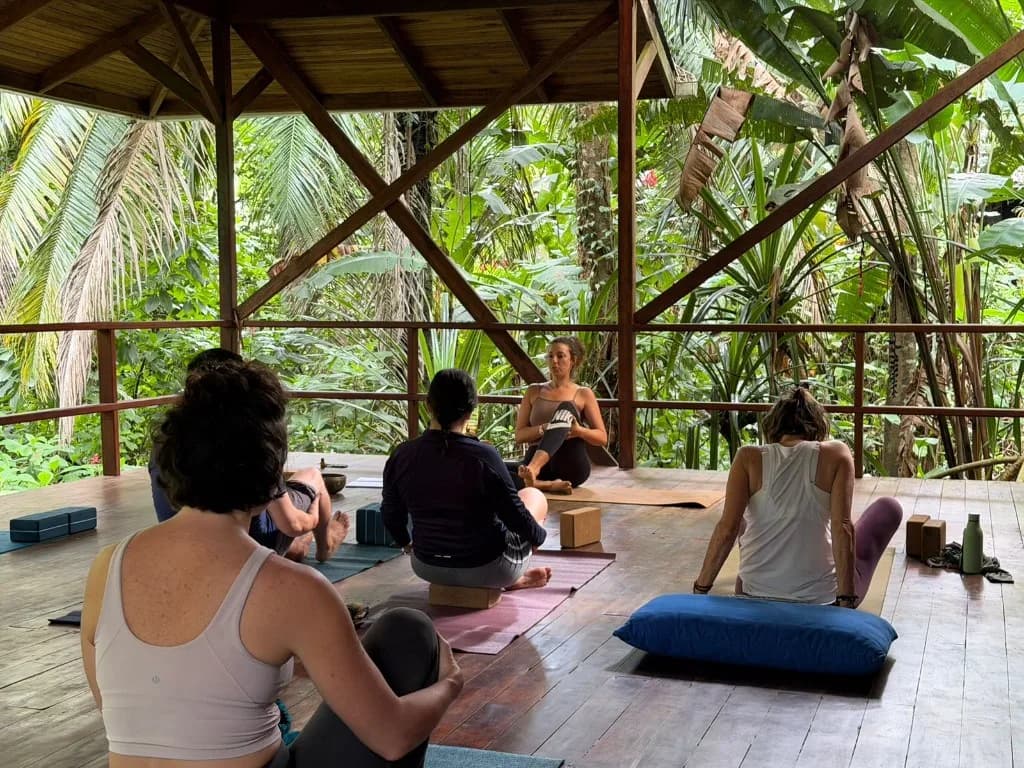 Marine leading a yoga class in the shala open to the jungle
